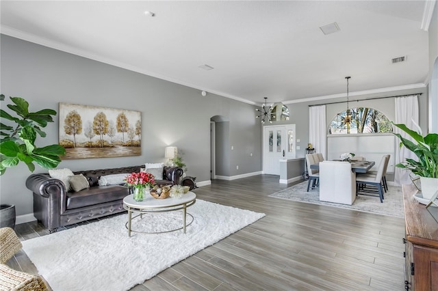 living area featuring baseboards, visible vents, arched walkways, and wood finished floors