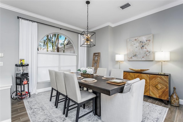 dining area with baseboards, ornamental molding, and wood tiled floor