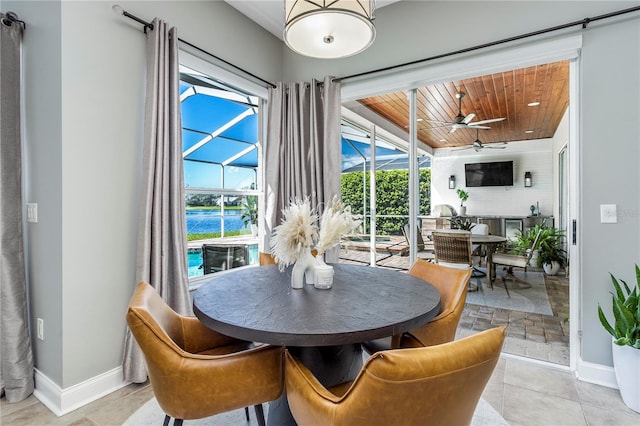 dining room with wood ceiling, ceiling fan, a sunroom, and baseboards