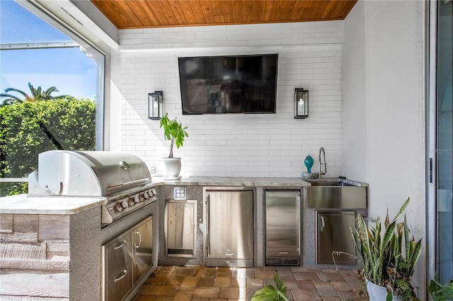 view of patio with a grill, an outdoor kitchen, and a sink