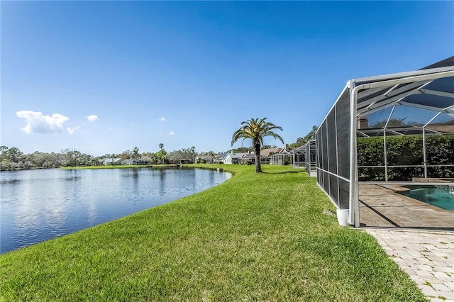 view of yard featuring glass enclosure, a water view, and an outdoor pool