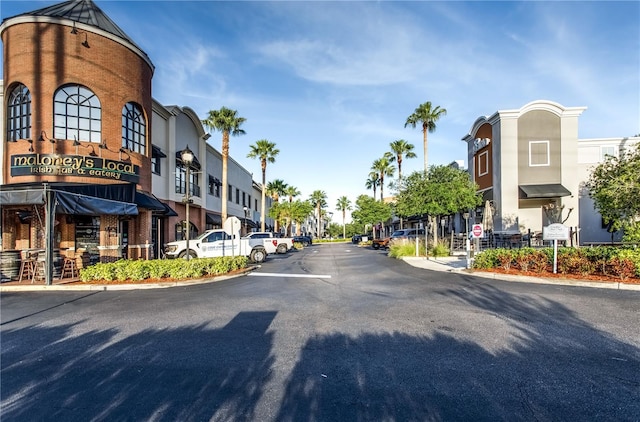 view of road with traffic signs, a residential view, and curbs