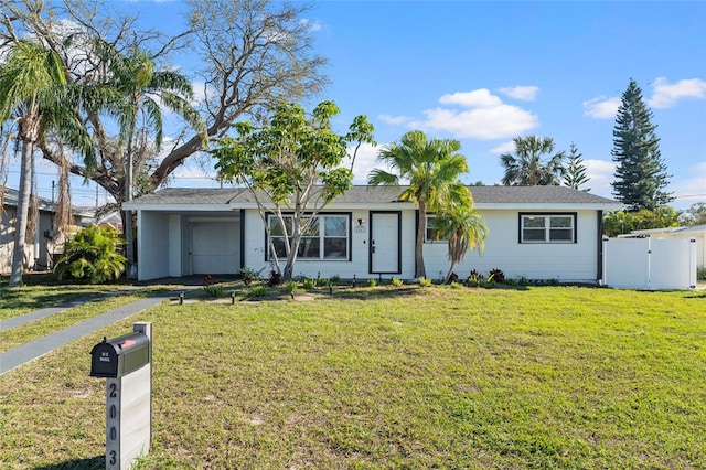 ranch-style home with a front yard, a gate, and fence