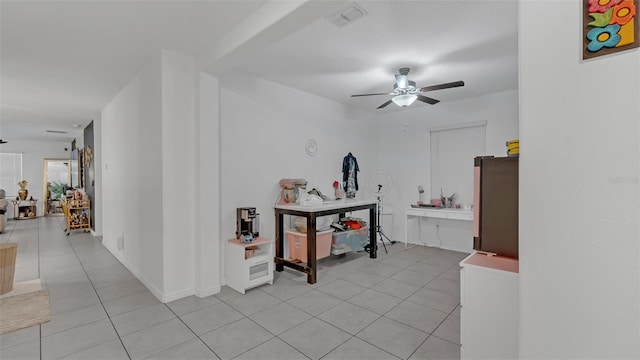 interior space with light tile patterned flooring, visible vents, and baseboards