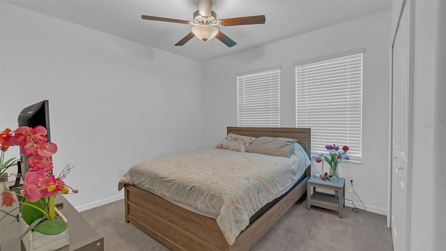 carpeted bedroom featuring ceiling fan and baseboards