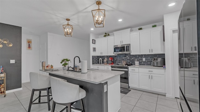 kitchen featuring light tile patterned floors, appliances with stainless steel finishes, backsplash, and a sink