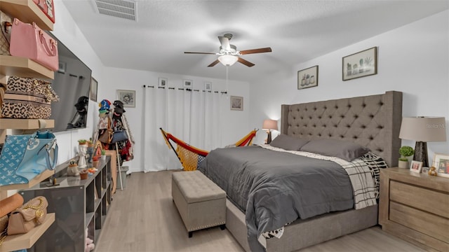 bedroom with a ceiling fan, visible vents, and light wood-style flooring