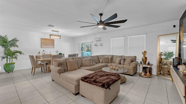 living room with light tile patterned floors, a textured ceiling, and visible vents