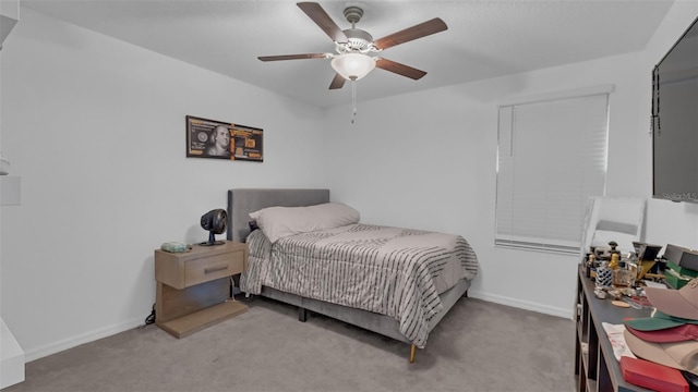 carpeted bedroom with ceiling fan and baseboards