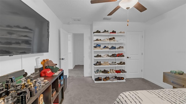 carpeted bedroom with baseboards, visible vents, and a ceiling fan