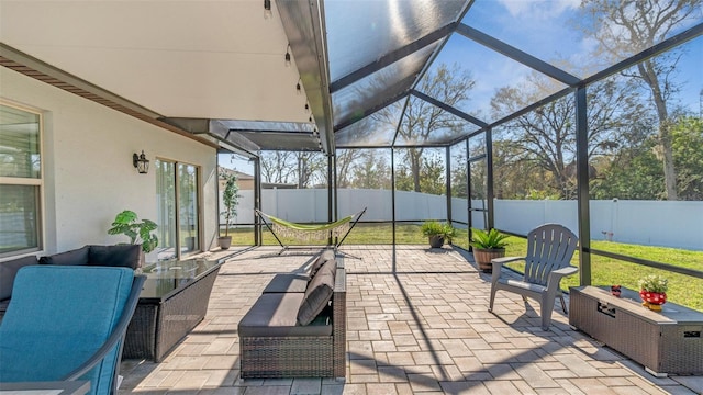 view of patio with glass enclosure and a fenced backyard