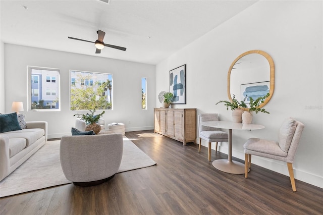 living area featuring a ceiling fan, baseboards, and wood finished floors