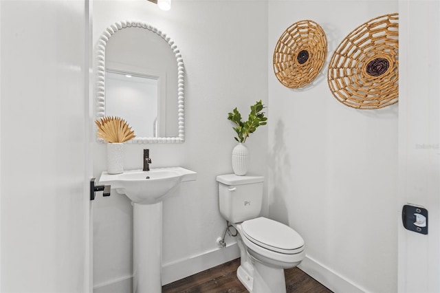 bathroom with a sink, wood finished floors, toilet, and baseboards