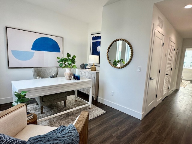 office area featuring dark wood-type flooring, visible vents, and baseboards