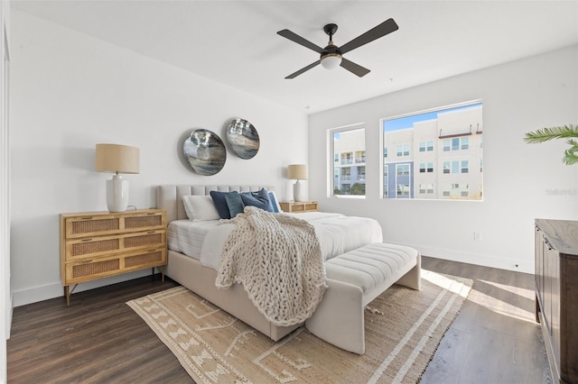 bedroom with dark wood finished floors, a ceiling fan, and baseboards