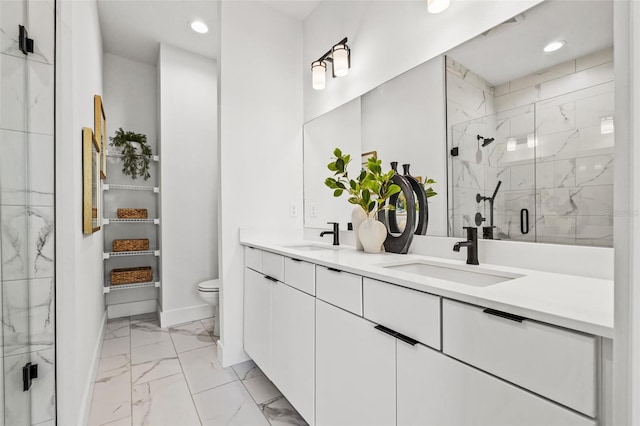 full bathroom featuring double vanity, marble finish floor, a marble finish shower, and a sink