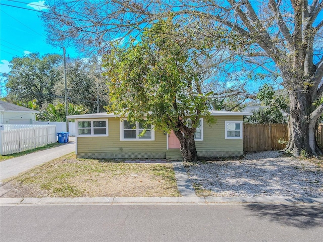 view of front facade with driveway and fence