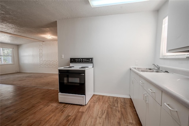 1800 27th Ave N, Saint Petersburg, FL 33713 - kitchen with light countertops, electric range oven, light wood-style floors, a sink, and a textured ceiling