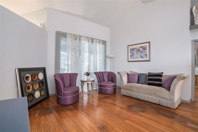 living room featuring high vaulted ceiling and wood finished floors