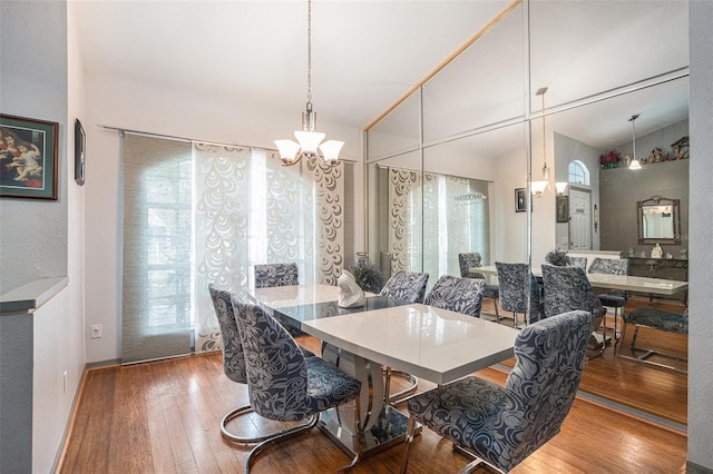 dining area with hardwood / wood-style floors and an inviting chandelier