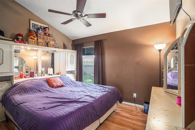 bedroom with a ceiling fan, baseboards, vaulted ceiling, and wood finished floors