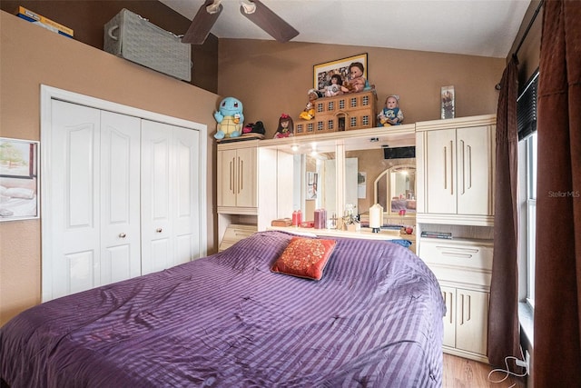 bedroom with vaulted ceiling, ceiling fan, light wood finished floors, and a closet