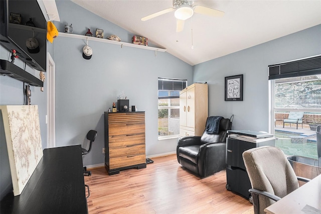 home office featuring light wood-style floors, vaulted ceiling, baseboards, and ceiling fan