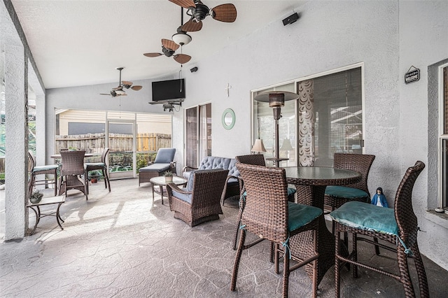 sunroom featuring lofted ceiling and a ceiling fan