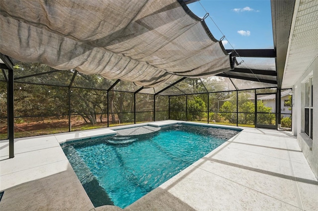 outdoor pool featuring glass enclosure and a patio