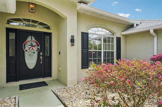 view of exterior entry featuring stucco siding