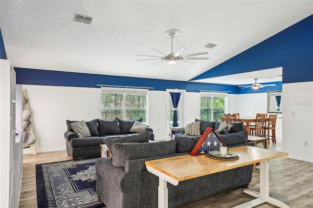 living area featuring a ceiling fan, visible vents, and wood finished floors