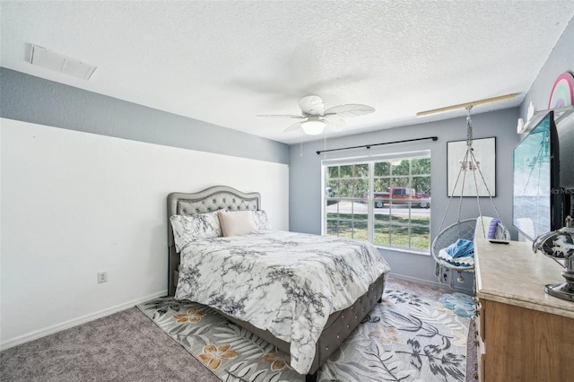 bedroom featuring light carpet, baseboards, visible vents, ceiling fan, and a textured ceiling