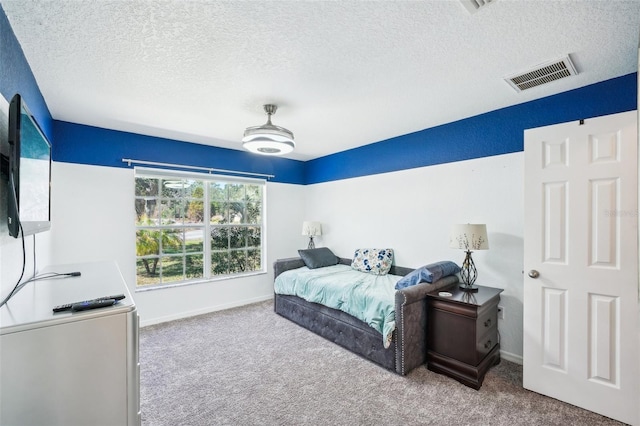 bedroom with carpet floors, baseboards, visible vents, and a textured ceiling