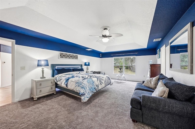 bedroom featuring carpet, visible vents, a raised ceiling, and a textured ceiling