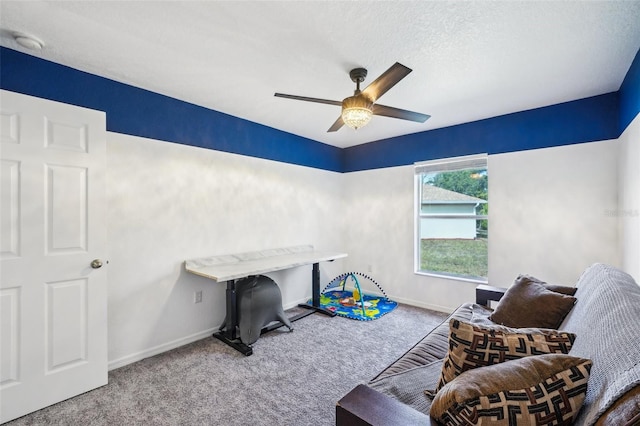 game room with carpet floors, ceiling fan, baseboards, and a textured ceiling