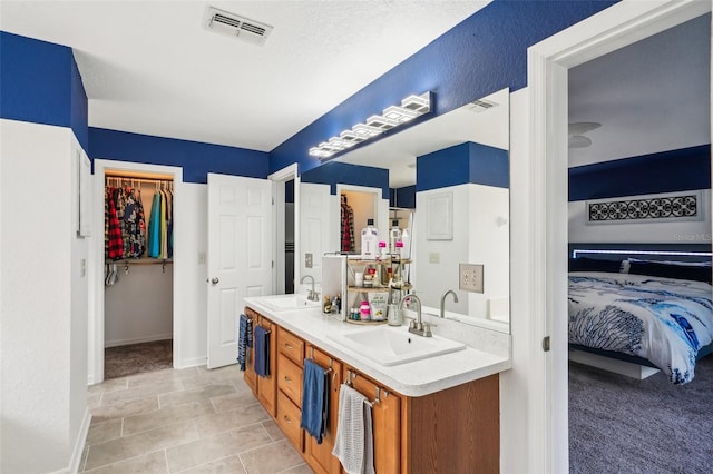 bathroom with double vanity, a sink, and visible vents