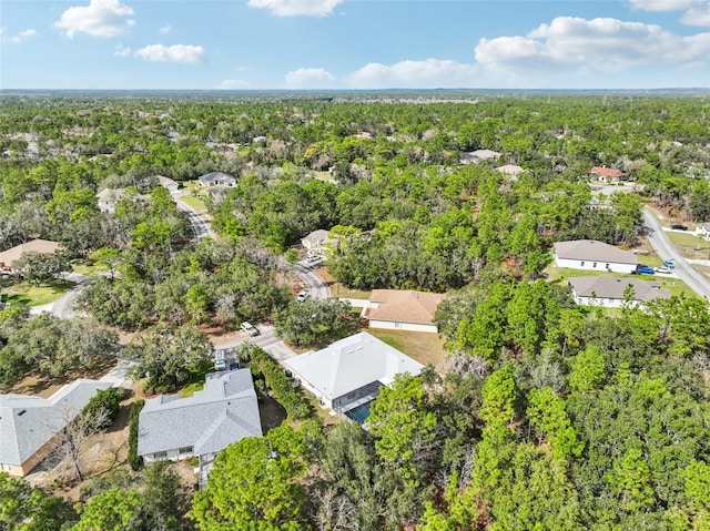 drone / aerial view featuring a residential view and a wooded view