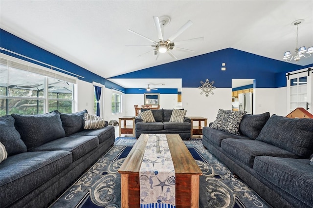 living area featuring vaulted ceiling and ceiling fan with notable chandelier