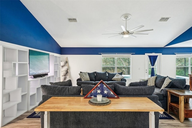 living area featuring lofted ceiling, ceiling fan, light wood-type flooring, and visible vents