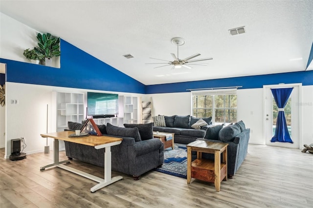 living area with visible vents, a textured ceiling, and wood finished floors