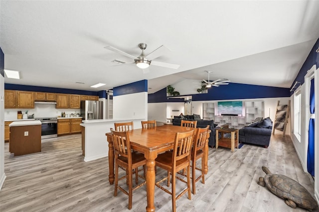 dining room featuring lofted ceiling, light wood-style flooring, and a ceiling fan