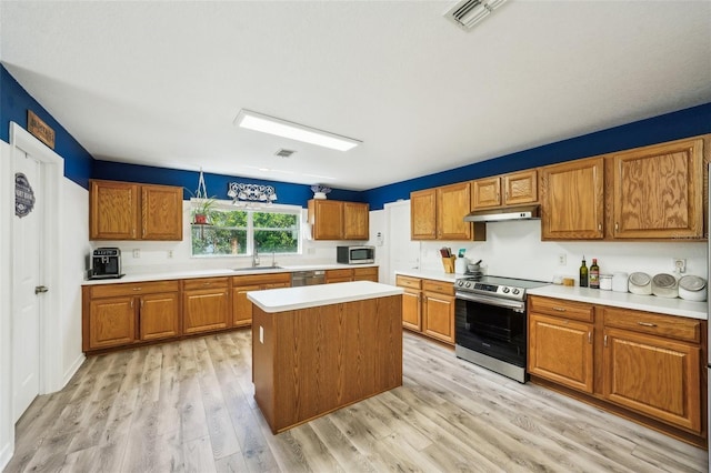 kitchen featuring visible vents, stainless steel appliances, light countertops, under cabinet range hood, and a sink