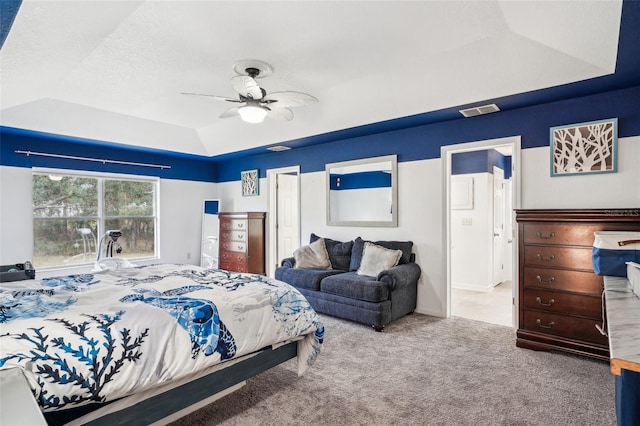 bedroom featuring carpet floors, visible vents, a ceiling fan, a closet, and a tray ceiling