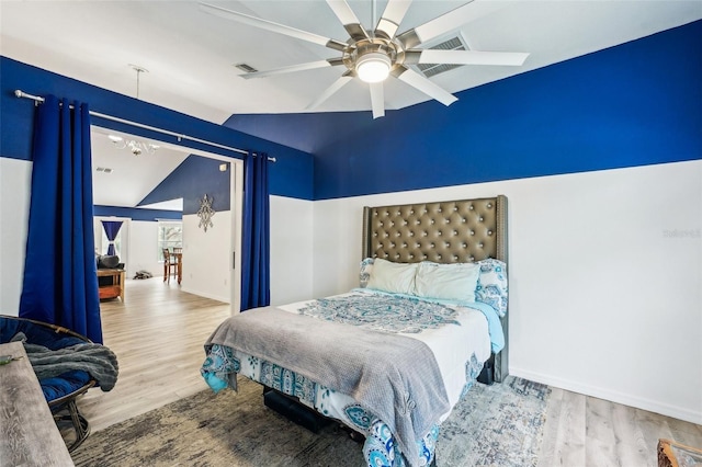 bedroom with baseboards, visible vents, ceiling fan, wood finished floors, and vaulted ceiling