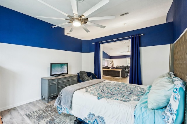 bedroom with ceiling fan, baseboards, visible vents, and light wood-style floors