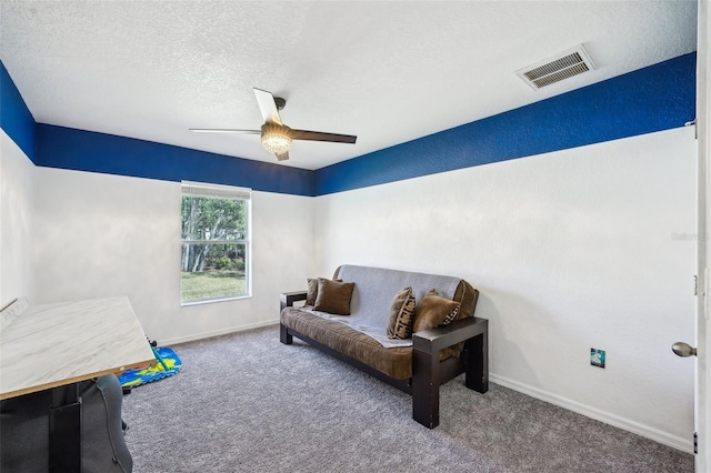 sitting room with a textured ceiling, a ceiling fan, visible vents, baseboards, and carpet