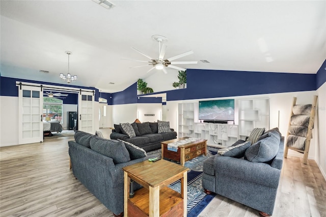 13 Witch Hazel Ct, Homosassa, FL 34446 - living room with a ceiling fan, a barn door, vaulted ceiling, wood finished floors, and a chandelier