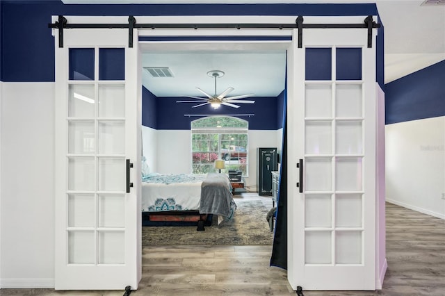 13 Witch Hazel Ct, Homosassa, FL 34446 - bedroom featuring a barn door, wood finished floors, and baseboards