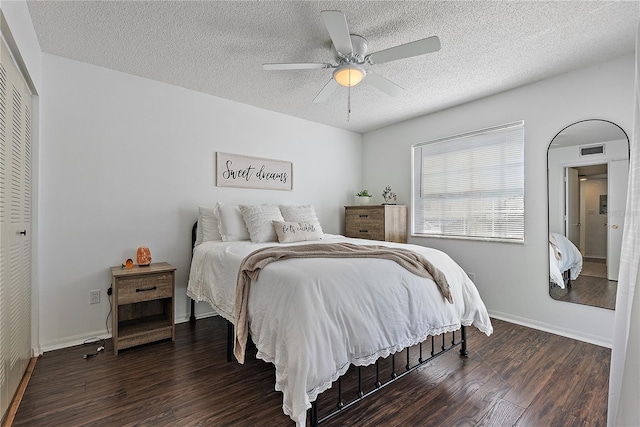 bedroom with a textured ceiling, wood finished floors, visible vents, and a ceiling fan