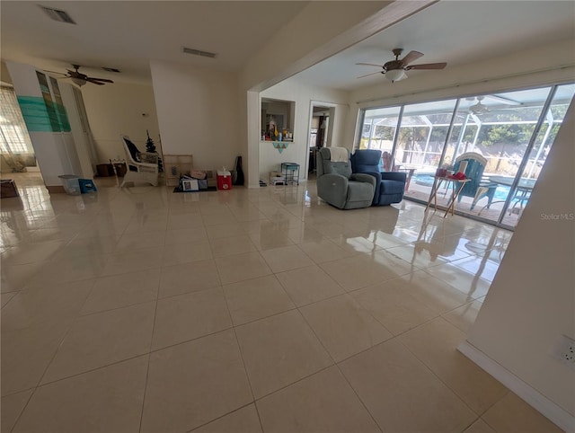 living area with ceiling fan, a sunroom, visible vents, and tile patterned floors